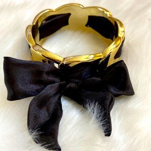 Cute goldtone bracelet with black ribbon.